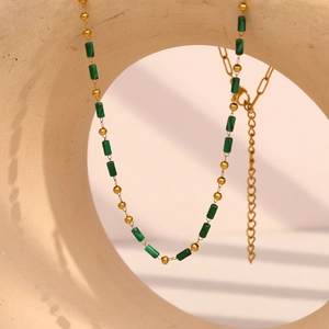 Detail of 18K gold plated necklace featuring green cylindrical stone beads and lobster clasp