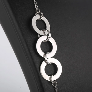 Macro shot of silver titanium steel interlocking geometric rings on black leather background