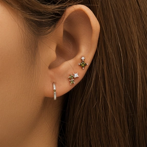 Macro shot of S925 silver earring set with turquoise and white crystals on ear