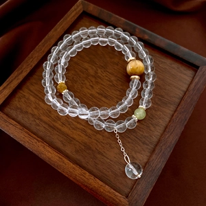 Detail of tiger eye and crystal double-layer beaded bracelet on walnut wood tray