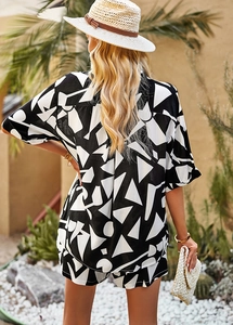 Rear view of woman in casual black and white geometric print shirt and shorts vacation set