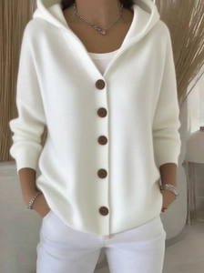Detailaufnahme der weißen Rippstrickjacke mit braunen Knöpfen und V-Ausschnitt Kapuze