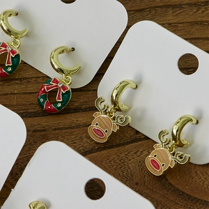 Christmas stud earring set featuring festive Santa and reindeer designs on a wood background