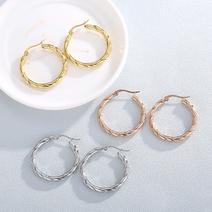 Dettaglio di orecchini a cerchio ritorti da 30mm in oro, oro rosa e argento