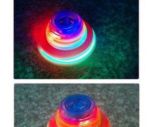Macro shot of LED glowing spinning top with vibrant neon light rings and transparent shell