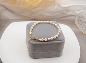 Detail of freshwater pearl bracelet with gold spacer beads on grey velvet jewelry box