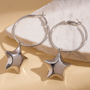 Polished silver star pendant hoop earrings on a marble slab for a high-end metal aesthetic