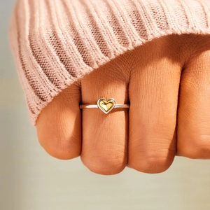 Minimalist S925 sterling silver two-tone heart ring worn on finger with knit sweater background