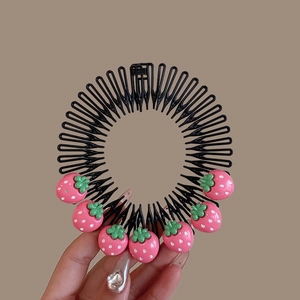 Detail of a black hair comb for girls featuring cute pink resin strawberry decorations