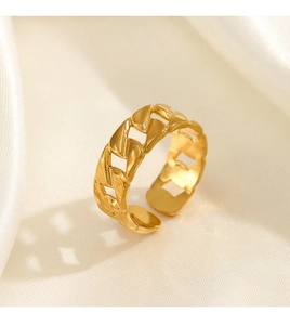 Close-up of golden chain-link open ring on cream silk fabric showing intricate texture
