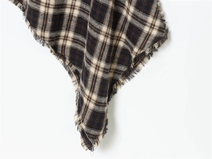 Close-up of brown and beige plaid pattern fabric with fringe tassel edge detail
