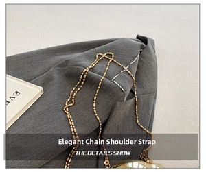 Macro detail of the golden metal chain strap and heart-shaped shell bag on grey fabric