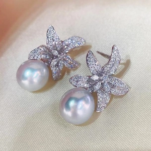 Elegant pearl starfish earrings with cubic zirconia and silver plating on silk background