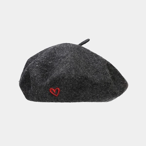 Detail of dark grey wool beret featuring retro style and red heart embroidery detail