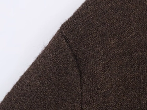 Dettaglio ravvicinato del cardigan in maglia marrone scuro con cuciture di alta qualità