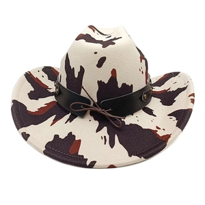 Detail of cow print cowboy hat with studded leather band and vintage style bow accent