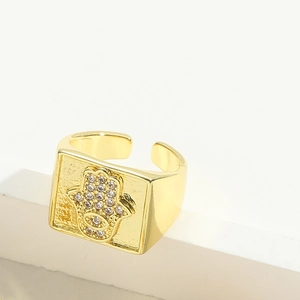 Detailed close-up of a gold Hamsa hand square ring with sparkling zircon inlays