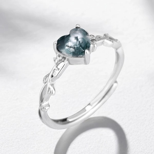 Macro shot of heart-shaped moss agate ring with vine-inspired silver-toned band details