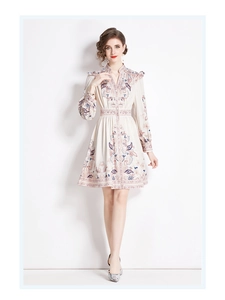 Dettaglio della stampa floreale vintage sull'abito beige a maniche lunghe con scollo a V