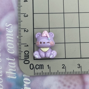 Purple resin bear figurine with pink hat on scale showing 2cm size for DIY crafts