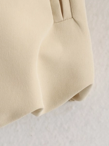 Macro detail of high-quality woven fabric with elegant pleats on a beige jacket
