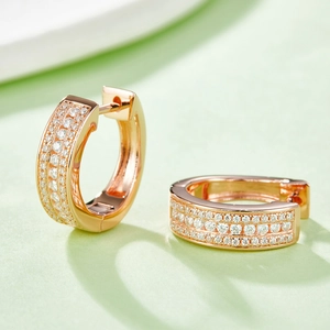 Detail showing rose gold huggie hoop earrings with multi-row pavé-set shimmering zircon stones