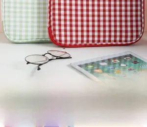 Close-up of red and green plaid laptop sleeves for iPad and 13-inch MacBook tablets