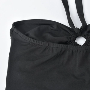 Close-up of black strapless top featuring metal ring buckle and tie-back detailing