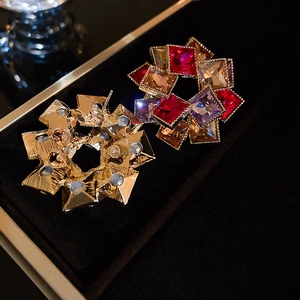 Gros plan de boucles d'oreilles géométriques en strass colorés sur velours noir
