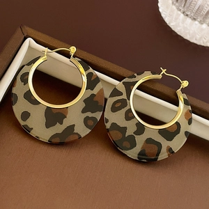 Macro shot of leopard print acrylic hoop earrings with gold metal posts in a gift box