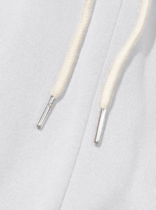 Detail of light gray fleece joggers featuring high-quality drawstring with silver metal tips