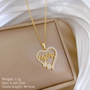 Macro detail of gold-plated heart pendant with MAMA letter carving and zircon inlay