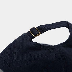 Detail of adjustable cotton baseball cap with vintage metal buckle and blue twill fabric