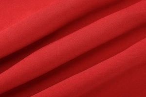 Detailed macro view of the premium red fabric texture and soft pleats of the tube dress