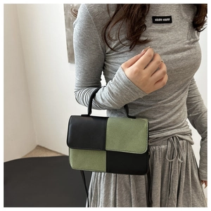 Dettaglio ravvicinato del patchwork in pelle a contrasto su una borsa a tracolla rettangolare