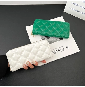 Detail of green and white glossy patent leather wallets with quilted diamond stitch pattern
