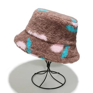 Dettaglio della trama del cappello alla pescatora marrone in sherpa con ciliegie