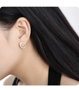 Close-up of model wearing silver irregular hollow earrings with sparkling crystals