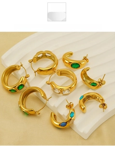 Gros plan de boucles d'oreilles créoles dorées 18k avec pierres précieuses colorées