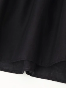 Close-up of black sleeveless shirt hem showing cotton blend texture and stitching detail