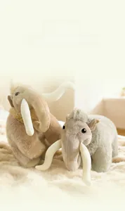 Close-up of plush mammoth toy with long tusks and soft fur texture on beige mat