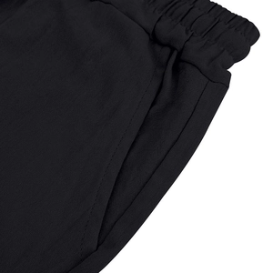 Close-up of black linen summer shorts featuring elastic waistband and functional side pockets