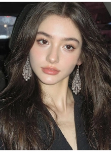 Detailed close-up of vintage hollow floral teardrop earrings worn by a female model