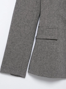 Detail of grey suit jacket sleeve cuff and flap pocket with textured fabric weave
