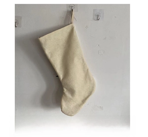 Detail view of the back of a cream white Christmas stocking with a hanging loop