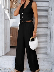 Detail shot of black vest and wide-leg trousers set with elegant lace trim details
