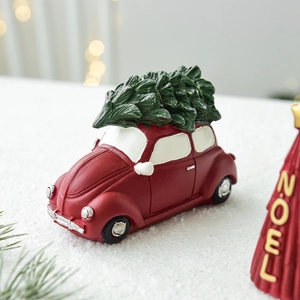 Voiture vintage rouge portant un sapin de Noël sur neige avec décor festif