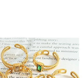 Detailed view of vintage gold plated rings featuring emerald green and white gemstones