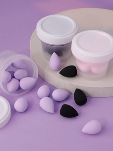 Mini teardrop makeup sponges in black and purple with frosted storage container