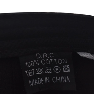 Detail view of the internal 100% cotton fabric label with wash symbols and rocker baseball cap info